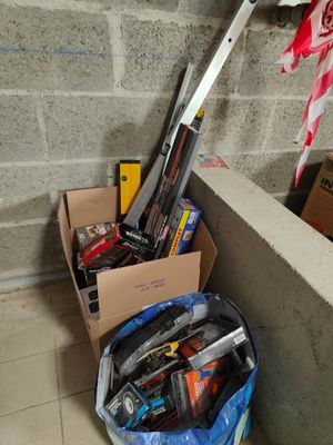 un tas d'objets divers dans une boîte posée par terre