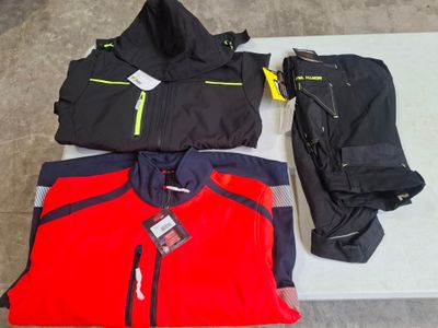 three jackets and a pair of pants sitting on a table