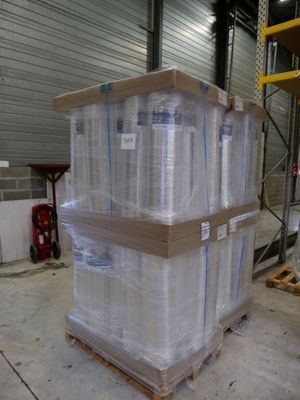 a large stack of pallets with clear plastic wrap on them