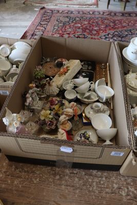 two boxes full of different types of china on the floor