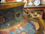 a large vase with a dragon handle on a table
