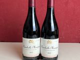 deux bouteilles de vin rouge sont posées sur une table à côté de deux autres bouteilles de vin rouge