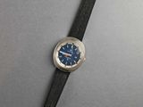 a close up of a watch on a table with a gray background