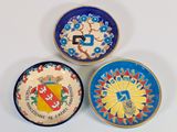 trois assiettes à motifs différents posées sur une surface blanche