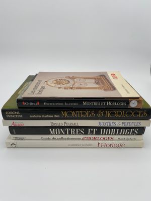 trois livres sont empilés sur une table