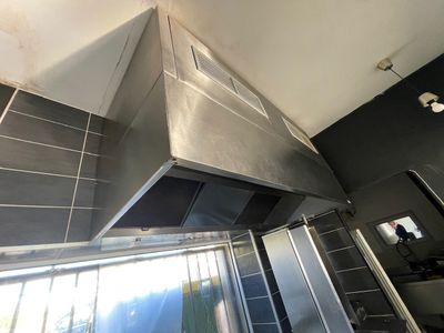 une photo d'une cuisine équipée d'une hotte en acier inoxydable