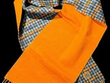 an orange scarf with a checkered pattern and a tag on it