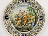 une assiette décorée d'une peinture, accrochée au mur