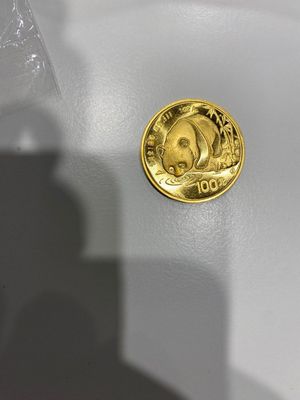 une pièce d'or posée sur une table blanche