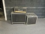 two amps sitting on top of each other in front of a brick wall