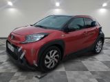 La Toyota C-HR rouge est garée sur un sol à damier.