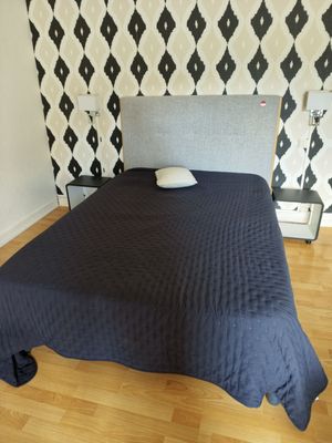 a bed that has a blue blanket on top of it