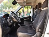 the interior of a white van with black seats and a steering wheel