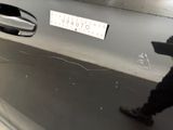 a person walking past a car with a sticker on it