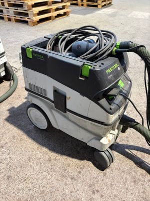 a green and black dust extracter sitting on the ground