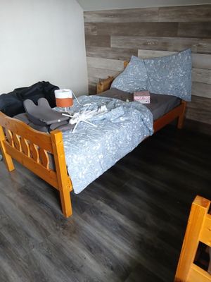 un lit avec une couette bleue et une tête de lit en bois