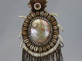 an image of a necklace with shells and beads on a stand