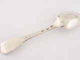 silver spoon on a white surface with a small spoon in the middle of it