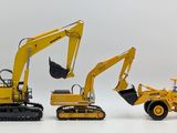 two toy construction vehicles that are sitting next to each other