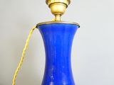 a blue vase with a gold handle on a table
