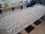 several rows of empty wine glasses on a table in a restaurant