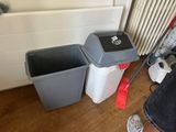 two trash cans sitting next to each other on the floor