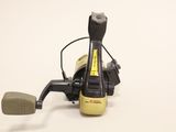 a close up of a fishing reel on a white surface
