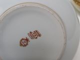 a white plate with a brown design on it sitting on a table