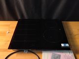 une photo d'une plaque de cuisson noire posée sur une table en bois