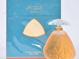 l'image d'un flacon de parfum posé à côté d'une boîte