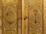 a gold cabinet with two doors and a clock on top of it