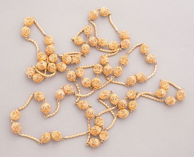 Colliers et bracelets à perles plaqués or sur un fond blanc