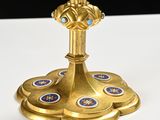 a gold candle holder on a white table with blue and gold decorations
