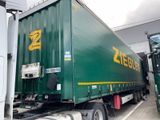 a large green semi truck parked in a parking lot