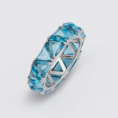 un gros plan d'une bague ornée de cristaux bleus sur fond blanc