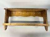 an old wooden shelf with a bunch of hooks on top of it