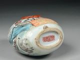 a white vase with a blue and orange design on it