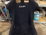 a close up of a black racing seat in a garage