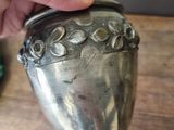 a person holding a silver container on a table