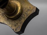 an antique brass telescope on a stand with a black base and a white background