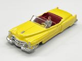 une petite voiture jaune avec un homme au volant et un autre sur la banquette arrière
