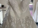 wedding dress hanging on a hanger in a bridal shop