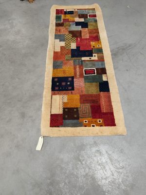 un grand tapis multicolore posé à même le sol dans une pièce