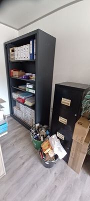 a black filing cabinet in the corner of a room
