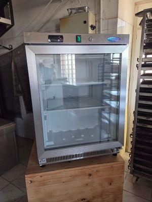 un réfrigérateur posé sur un meuble en bois dans une cuisine