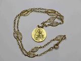Gros plan sur un collier en or sur lequel se trouve une pièce de monnaie