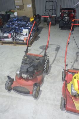 deux tondeuses à gazon qui sont rangées dans le garage