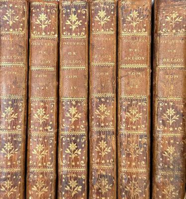 a close up of a row of old books on a shelf
