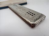 a silver harmonica sitting on a table next to a wooden block