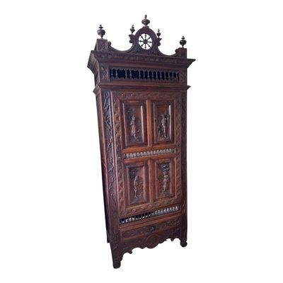 une vieille armoire en bois dont les portes sont ornées de sculptures
